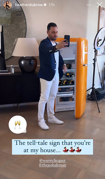 Josh Altman taking a photo with Heather Dubrow's champagne fridge.