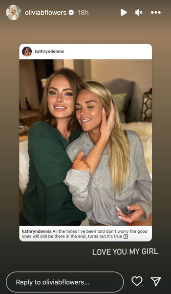Kathryn Dennis and Olivia Flowers sitting on a couch together as Kathryn nuzzles Olivia's face towards hers.