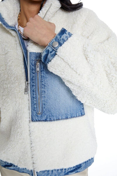 A model wearing a denim and fleece jacket.