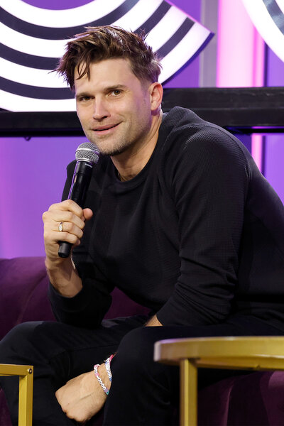 Tom Schwartz smiles while talking in the microphone during a panel at BravoCon 2023