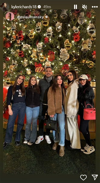 Kyle Richards posing with her family in front of a large Christmas tree.