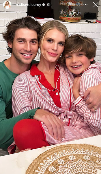 Madison LeCroy, Brett Randle, and Hudson Hughes hug and smile while wearing holiday pajamas together.