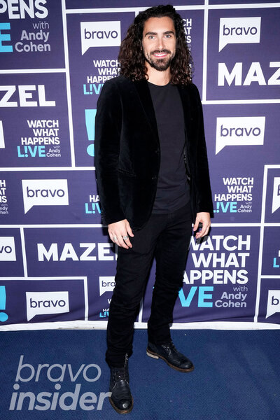 Alex Propson wearing an all black outfit in front of a step and repeat at the Watch What Happens Live clubhouse in New York City.
