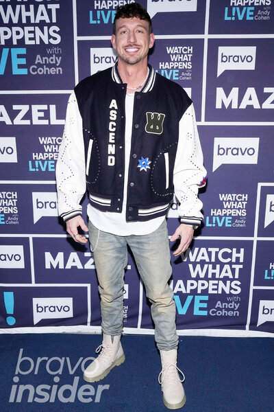 Kory Keefer wearing a varsity jacket and jeans in front of a step and repeat at the Watch What Happens Live clubhouse in New York City.