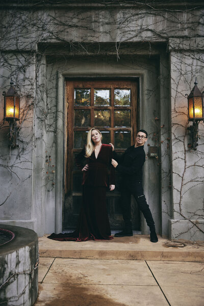 Christina Applegate and Christian Siriano pose together outside of a rustic doorway.
