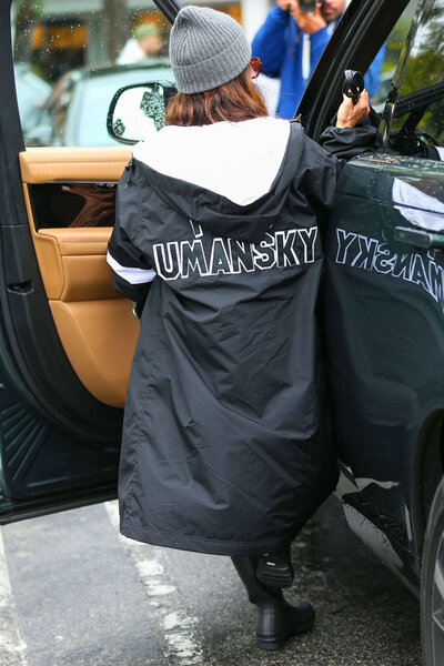 Kyle Ricahrds wearing a long black coat that says "Umasky" on the back.