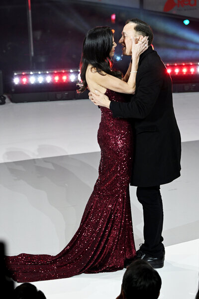 Heather Dubrow and Terry Dubrow embracing on a stage.