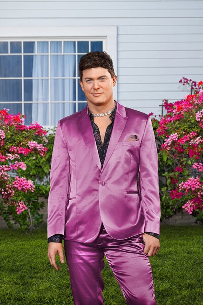 Zack Wickham wearing a purple suite on a front lawn.