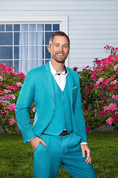 Luke Broderick wearing a blue suit on a grass lawn