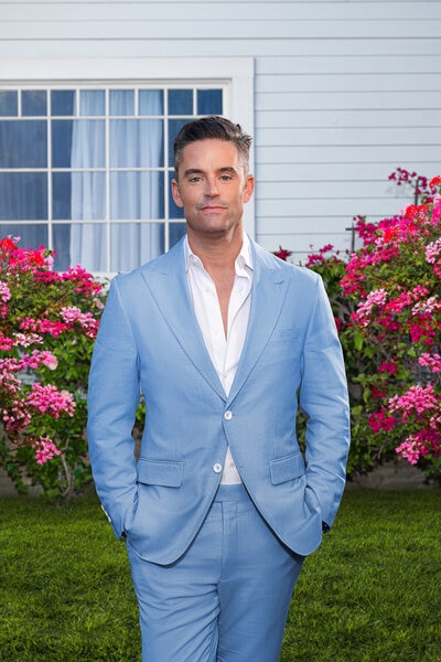 Jesse Lally wearing a blue suit on a grass lawn