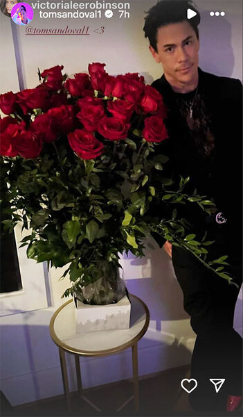 Tom Sandoval standing by a large bouquet of roses on Valentine's Day.