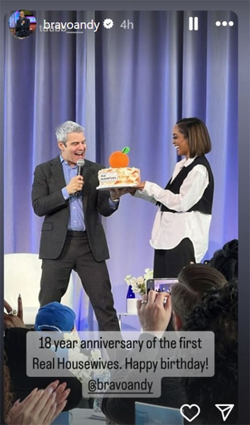 Andy Cohen onstage receiving a cake for The Real Housewives of Orange County's 18th Anniversary.