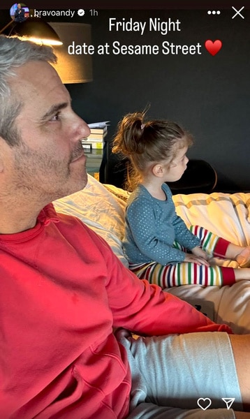 Andy Cohen and his daughter Lucy Cohen sitting on a couch watching TV