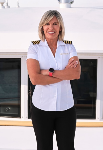 Captain Sandy wearing her yachting uniform on a boat marina.