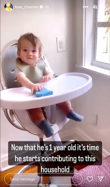 Kate Chastain's son Sullivan Chastain in his high chair cleaning it with a sponge.