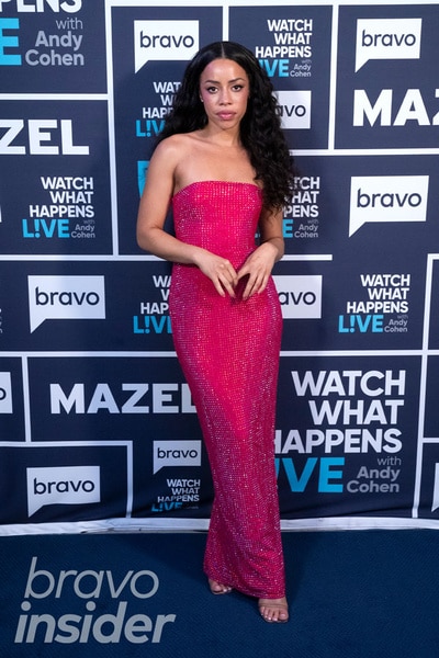 Full length of Summer Marie Thomas wearing a pink dress in front of the Watch What Happens step and repeat