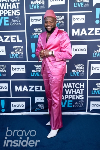 Full length of Preston Mitchum wearing a pink suit in front of the Watch What Happens step and repeat
