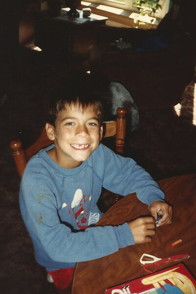 Jax Taylor plays with crayons at a table as a young boy.