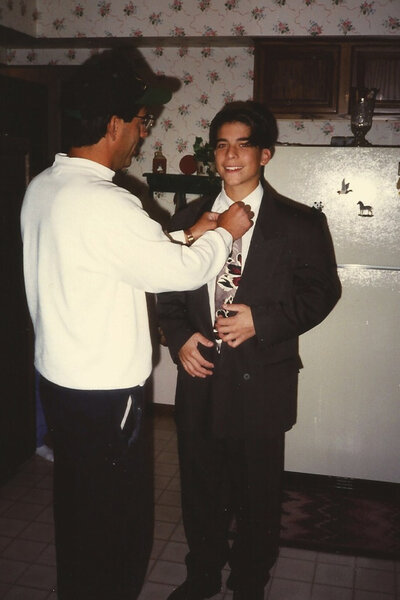 Jax Taylor with a family member who is fixing the tie on his suit.