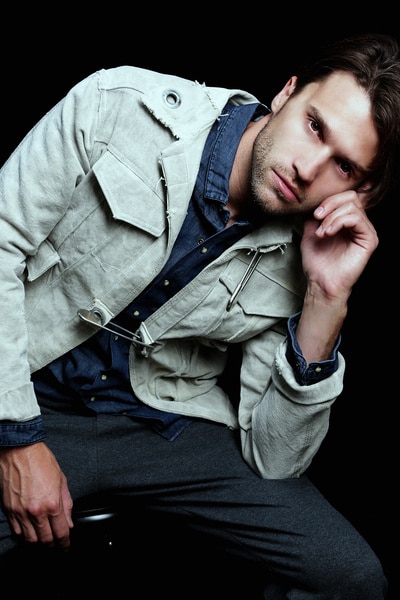 Tom Schwartz modeling a denim jacket with his hand on his head