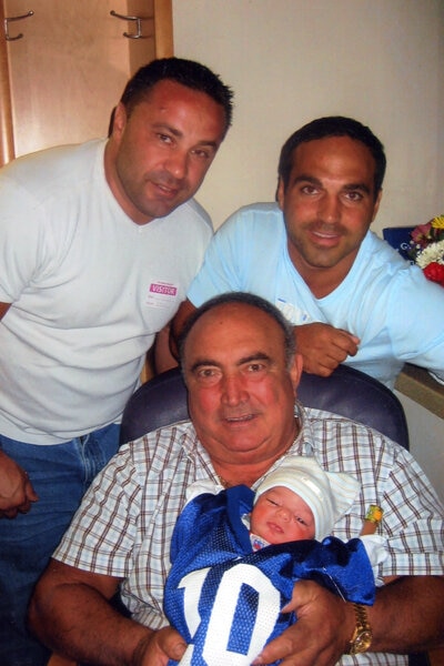 Joe Gorga posing with his father and newborn baby.