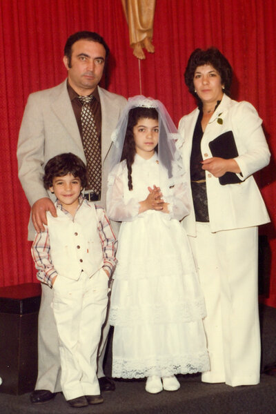 Young Joe Gorga and Teresa Giudice posing with their parents in white outfits.