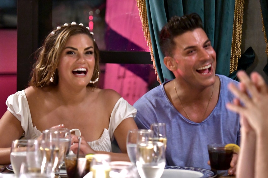 Brittany Cartwright and Jax Taylor laughing at a dining table.