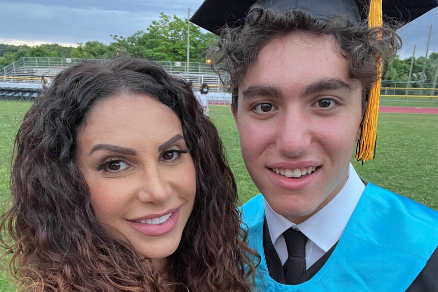 Jennifer Aydin and her son Justin Aydin together on a football field during his highschool graduation.