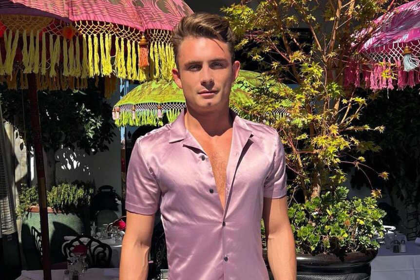 James Kennedy posing outside of SUR wearing a pink shirt.