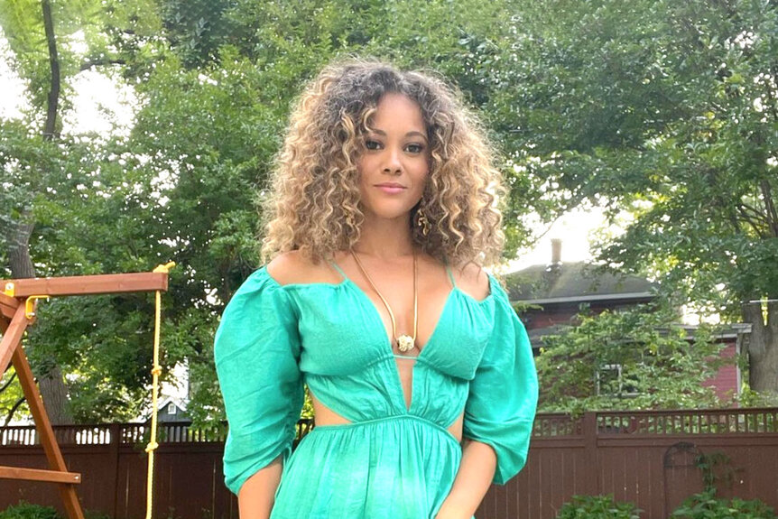 Ashley Darby wearing a green dress and posing for a photo.