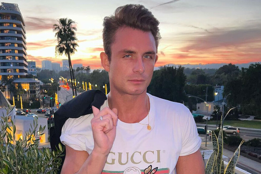 James wearing a Gucci shirt with a sunset in the background.