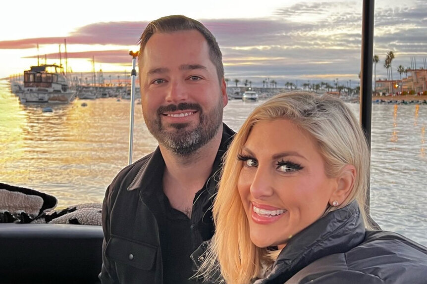 Gina Kirschenheiter and Travis Mullen smile together on a boat.