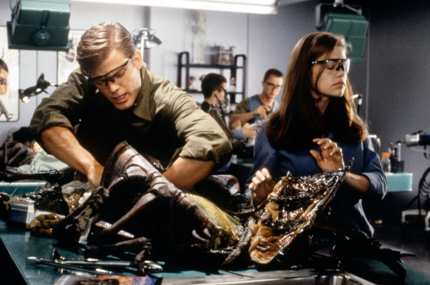 Casper Van Dien and Denise Richards on the set of Starship Troopers disecting an animal.