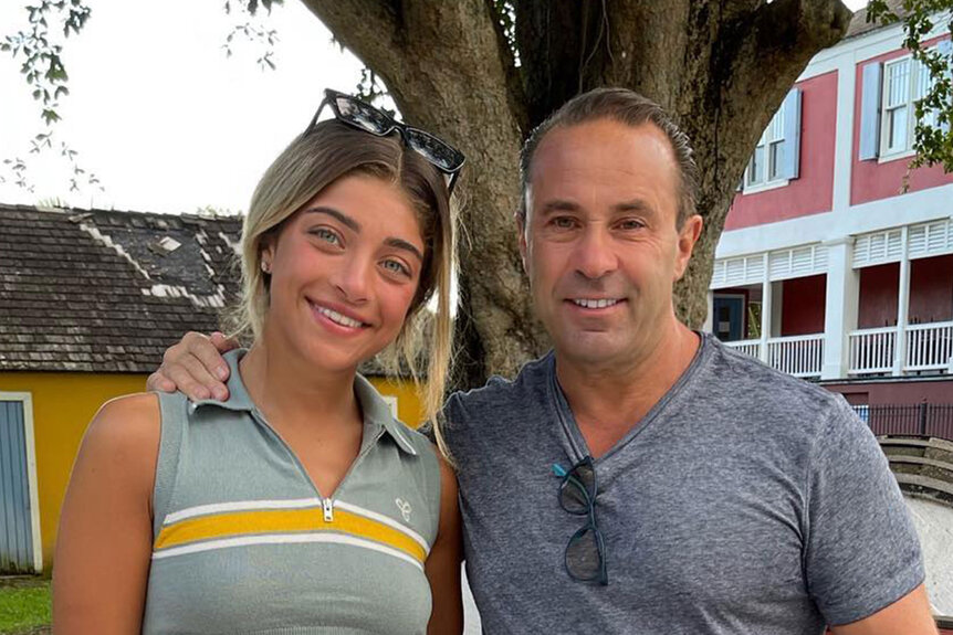 Joe Giudice and Gia Giudice posing together in front of a tree in casual outfits.