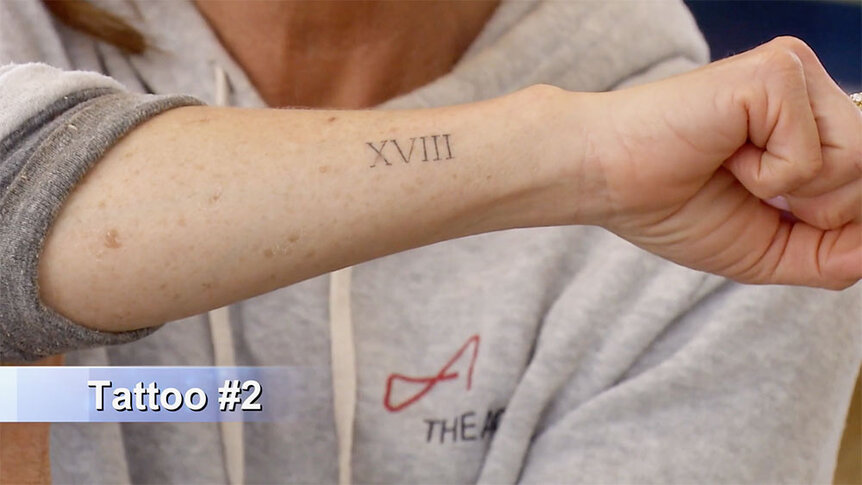 Kyle Richards showing Mauricio Umansky a roman numeral tattoo on her forearm.