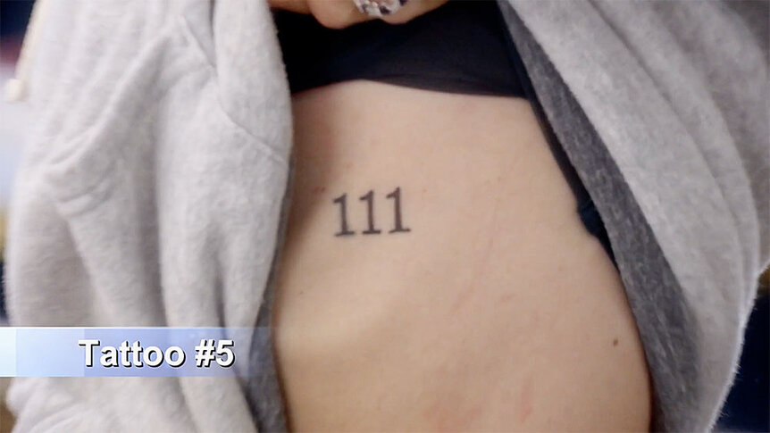 Kyle Richards showing Mauricio Umansky a "111" tattoo on her ribcage.