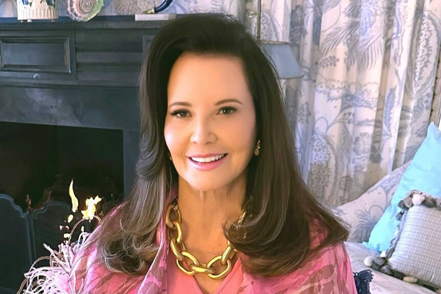 Patricia Altschul smiling in a pink outfit while sitting.