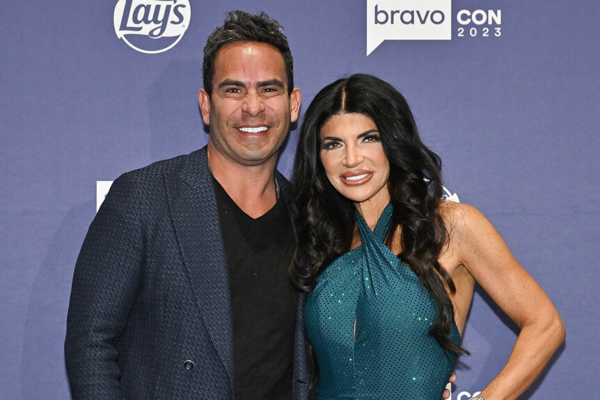 Teresa Giudice and Louie Ruelas pose in front of a step and repeat at BravoCon 2023.