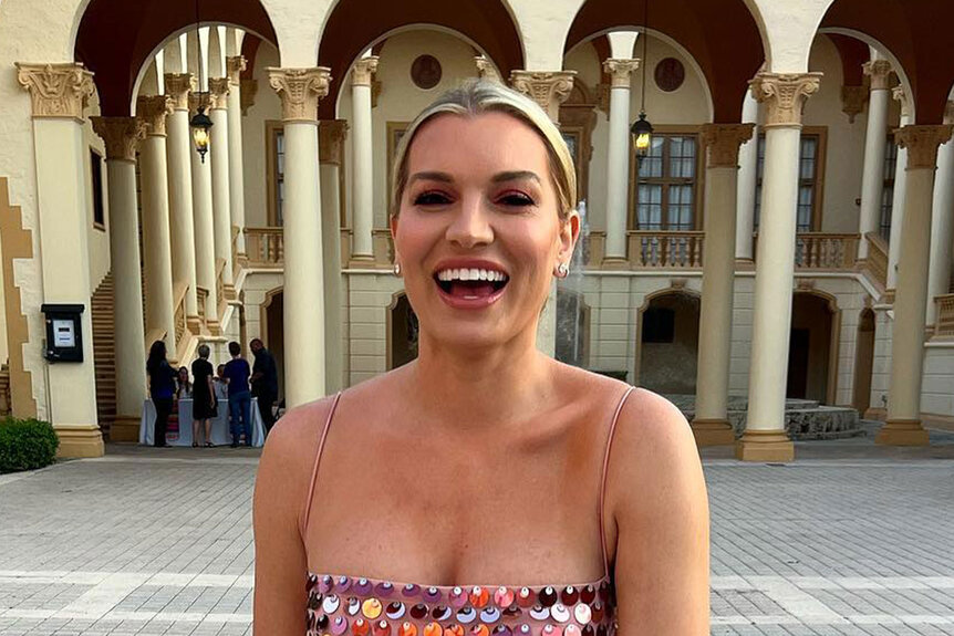 Lindsay Hubbard smiling and laughing in a pink, metallic, dress in Miami.