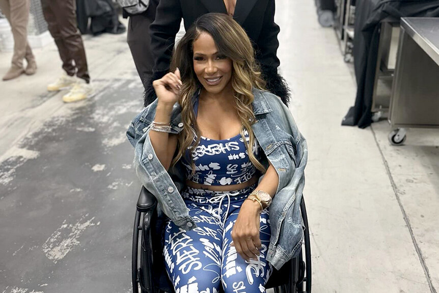 Sheree Whitfield gets pushed in a wheelchair while backstage at Bravocon 2023.