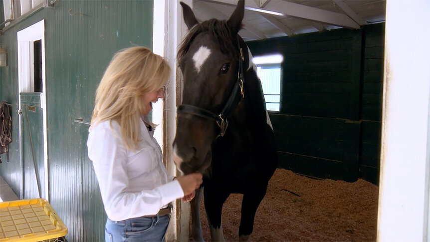 Sutton Stracke visiting her horse, Santos, in his stable at the Paddock Riding Club.