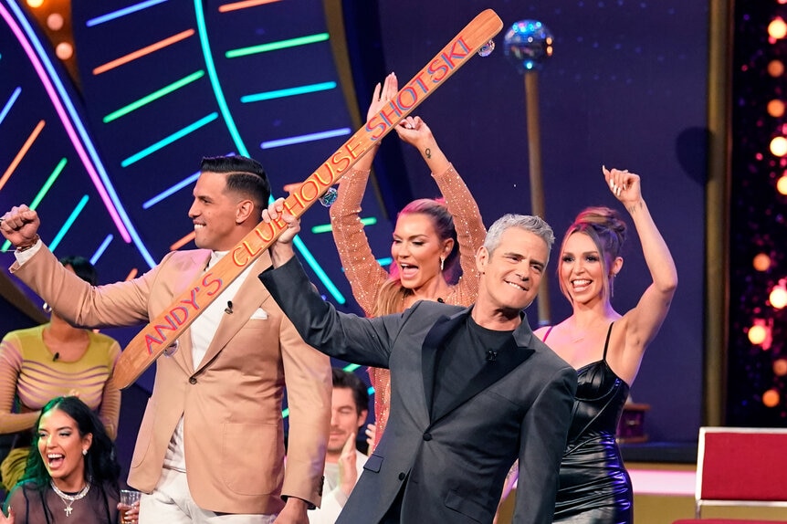 Andy Cohen holding the WWHL Shotski while on stage with Shouthern Charm, Vanderpump Rules, and Winter House casts.