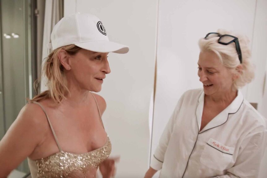 Dorinda Medley wears a white shirt and admires Sonja Morgan's boobs in her gold bathing suit.