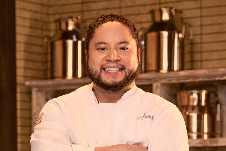 Kenny Nguyen wearing a chef's uniform in a kitchen pantry