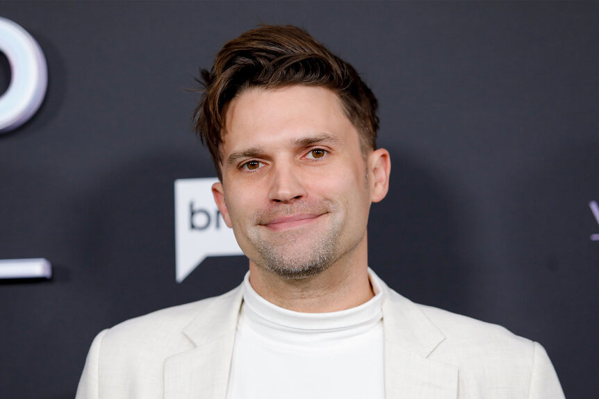 Tom Schwartz smiling in front of a step and repeat.