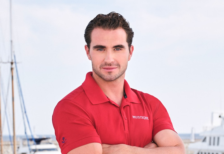 Joe Bradley wearing a red polo on a boat marina