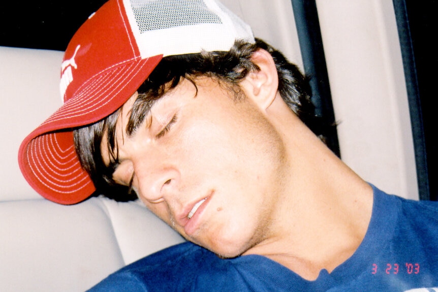 Jax Taylor taking a nap with long hair and a trucker hat.