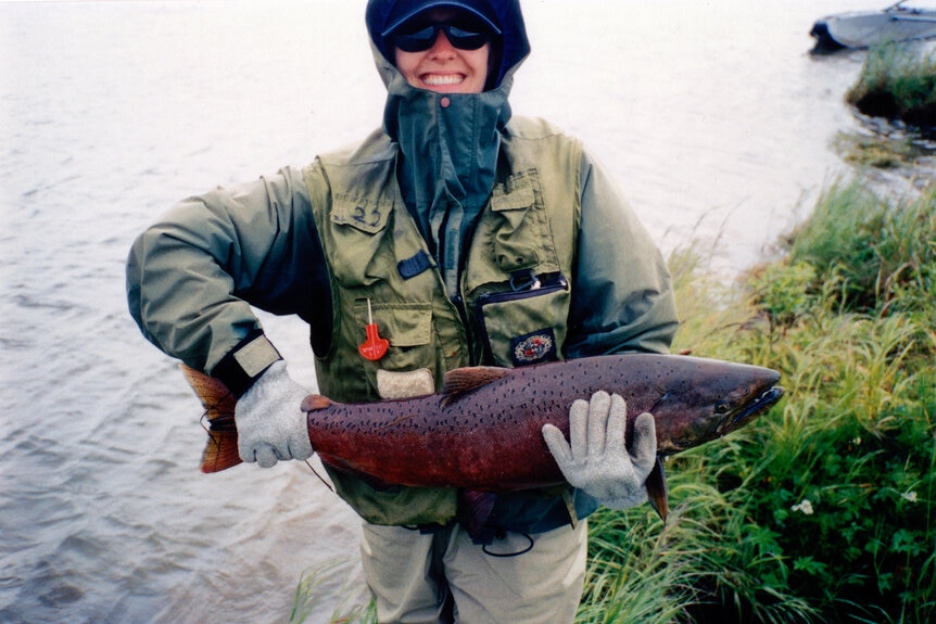 Erika Jayne wearing camouflage and holding a large fish