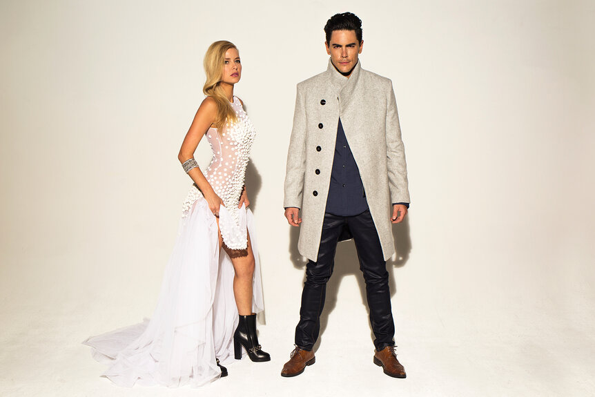 Ariana Madix and Tom Sandoval posing together in front of a white background.