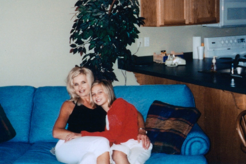 Lala Kent sits on a couch while hugging her mother.